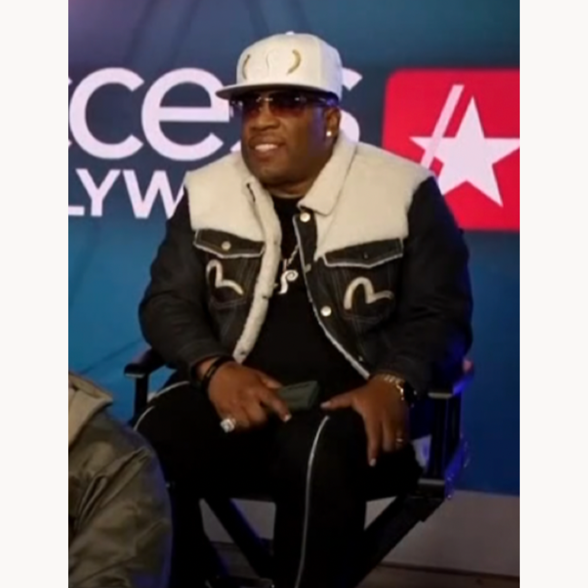 Michael Bivins wearing sherpa-lined Evisu dark indigo trucker denim jacket on Access Hollywood 2025