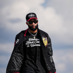 KhaDarel Hodge wearing black varsity letterman jacket with red and gold patches from NFL x HBCU